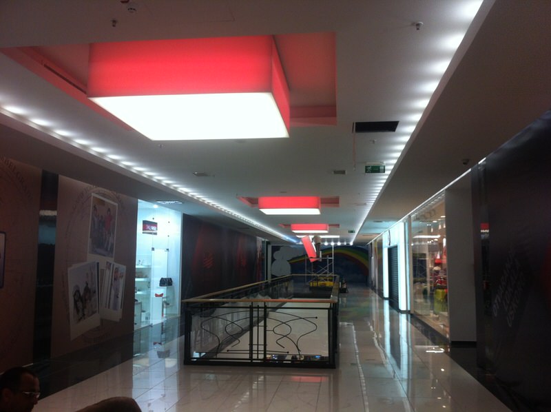 Áruházi belsőtér. Oldalt RGB, lefelé fénycső világítás.