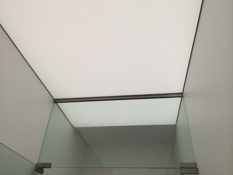 Folyosói Barrisol álmennyezet világítás folyamatos áthaladása szerkezeti váltásnál.